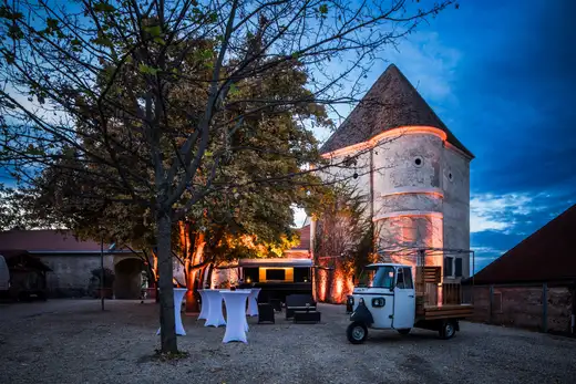 Beleuchteter Innenhof mit historischem Rundturm am Abend