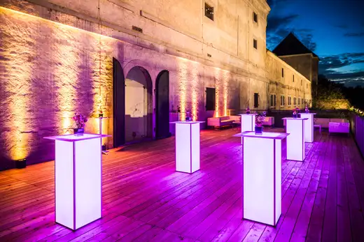 Neu gestaltete Terrasse mit beleuchteten Stehtischen